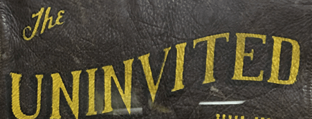 Image of leather with gold "The Uninvited" text